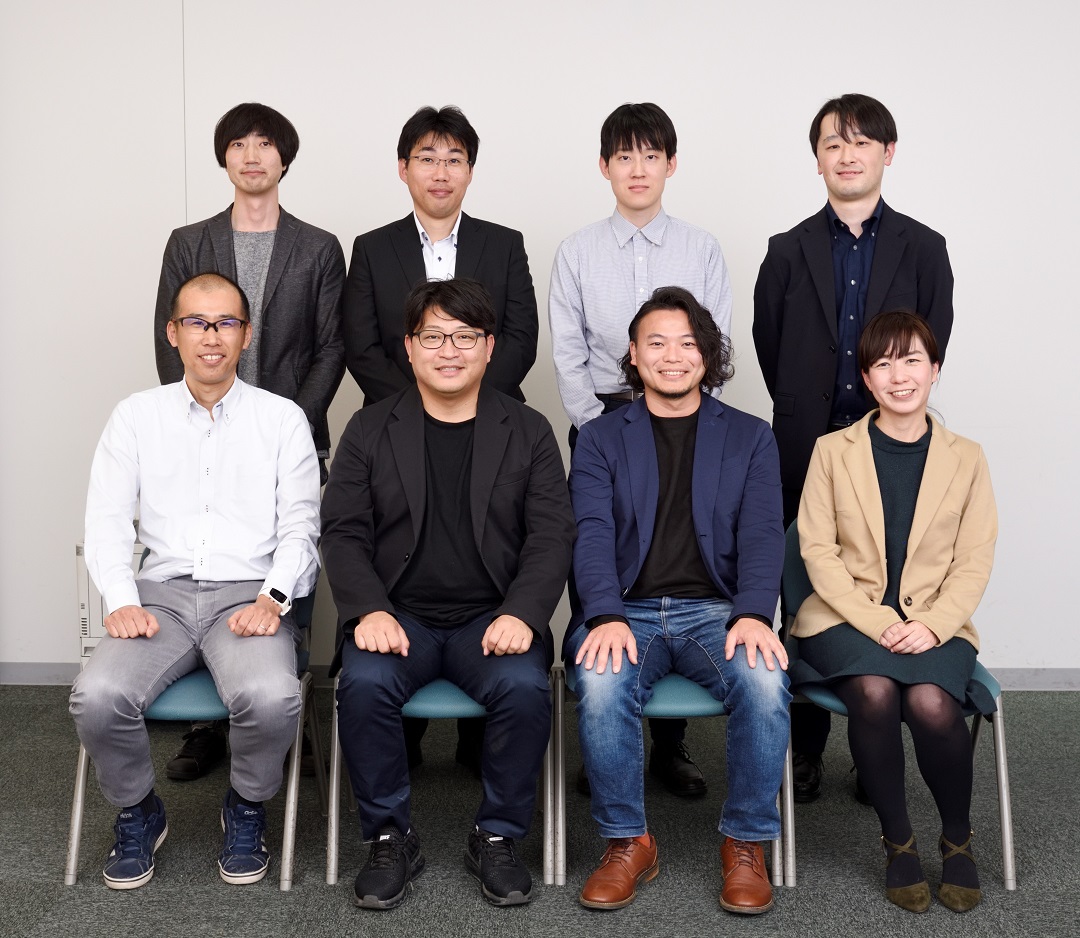 写真：後列左から、つくば市 工藤侑士氏、櫻井亮輔氏、三菱総研ＤＣＳ 藤田知秀、米沢勝、前列左から、つくば市 藤原稔久氏、つくばクラフトビアフェスト実行委員会 中山尚紀氏、永田洋氏、三菱総研ＤＣＳ 西岡裕子 （撮影場所：つくば市役所にて）